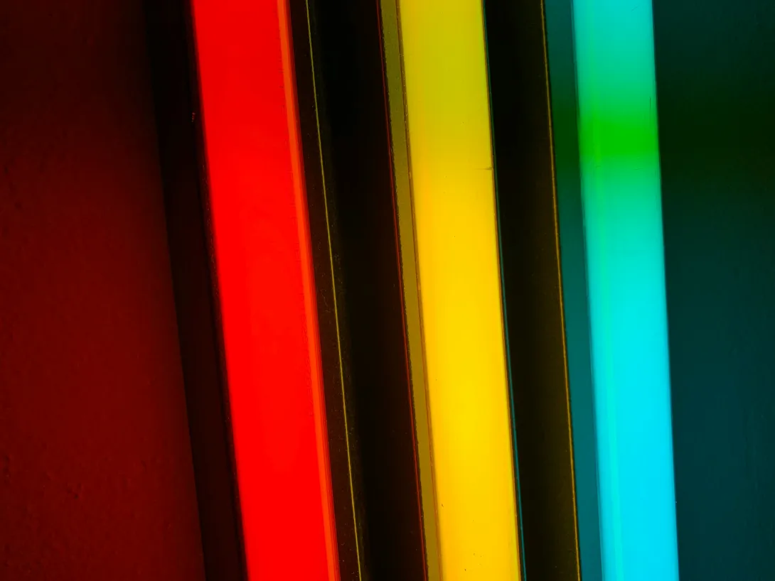 Three bars of light. From left to right: Red, yellow, and cyan. The bars of light are three dimensional showing some depth in a rectangular shape.